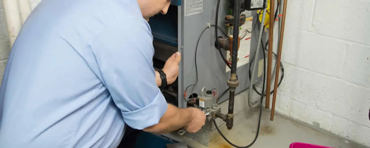 Furnace repair technician inspecting and servicing a home heating system in Orange, CA
