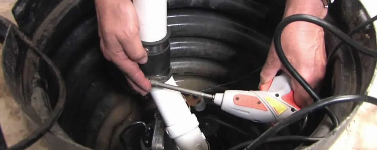 Sump pump installation technician connecting PVC discharge piping in Orange, CA
